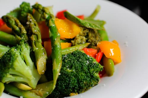 Salada de legume e vegetais, servida em um prato branco.