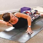 Como Aumentar a Mobilidade dos Ombros? 5 Melhores Exercícios Mulher fazendo alongamento dos ombros no colchonete