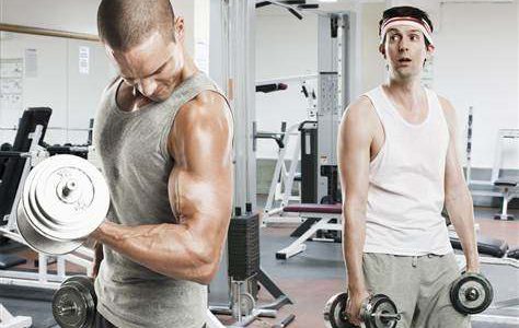 Resultados na Academia Demoram Quanto Tempo? Homem fraco olhando homem forte malhar