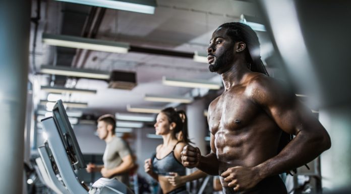 Cardio em Jejum (AEJ) Realmente Queima Gordura? Homem negro exercitando-se na esteira sem camisa