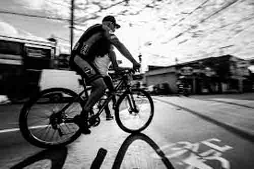 Homem pedalando na rua