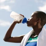 Como tomar albumina para ganhar massa muscular? Atleta consumindo albumina como suplementação pós-treino