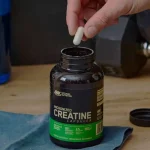 Como tomar creatina em cápsulas? Guia completo para uso eficaz Pessoa pegando creatina em cápsulas