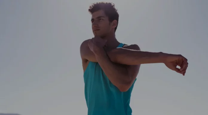 A importância do aquecimento antes do treino: benefícios e como fazer Homem aquecendo os braços antes de treinar