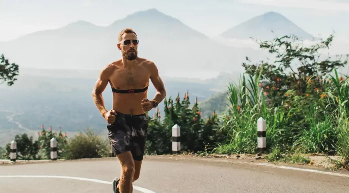 Quantas vezes correr na semana? Veja a frequência ideal! homem correndo na rua com morros ao fundo